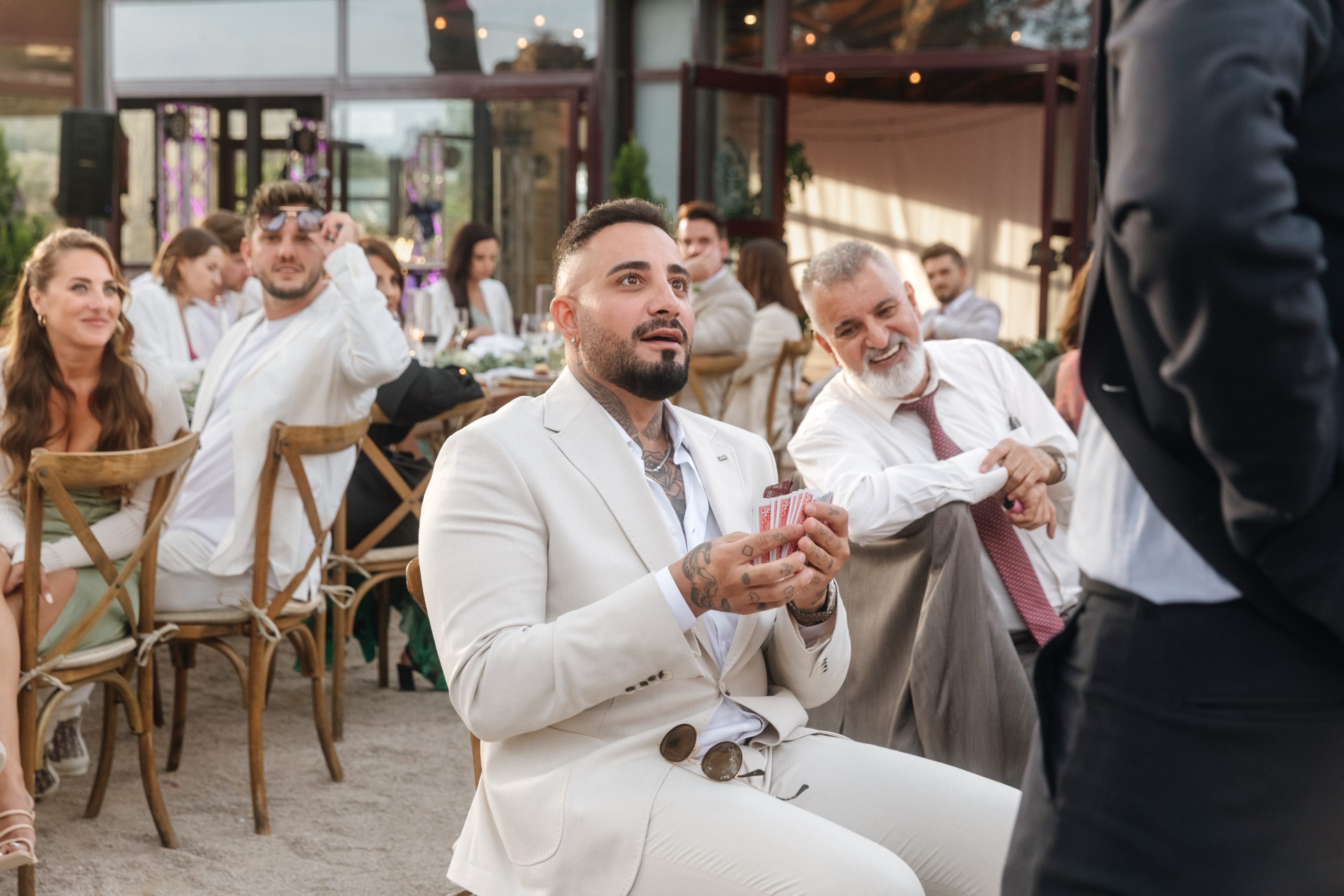 Wedding cocktail hour entertainment with guests enjoying close-up magic during a drinks reception